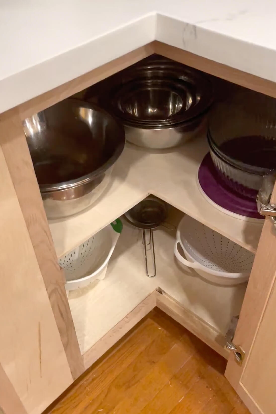 Full shelves on a kitchen cabinet after removing a lazy susan.